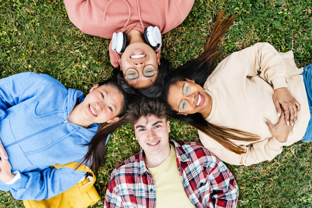 Group of teens relaxing in the grass – symbolising safe, supportive therapy for teenagers in Nottingham and online